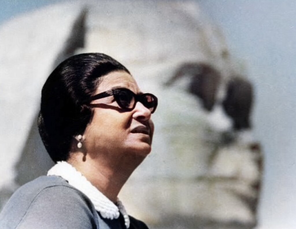 Umm Kulthum nel 1969 davanti alla Sfinge di Giza, Egitto. <br>Fonte: <a href=https://commons.wikimedia.org/wiki/File:Umm_Kulthum_1969.jpg>Wikimedia Commons</a>.